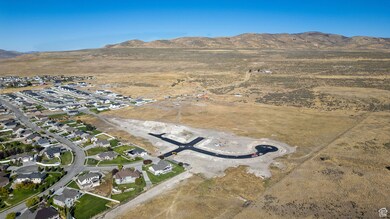 Aerial overview of property's location with a mountainous background and nearby suburban area
