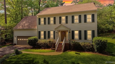 Colonial home featuring concrete driveway, a shing