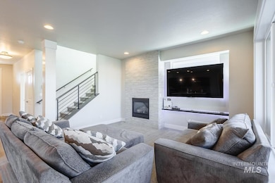 Living area featuring recessed lighting, a fireplace, and stairway
