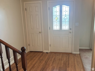Entryway featuring light wood-style flooring, stairs, and crown molding