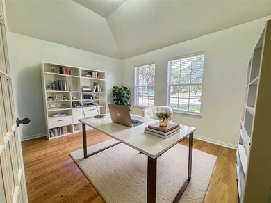 Virtually staged - Glass doors gracefully lead into the home office, offering both flexibility and views of the front yard. It's a versatile and inviting space.