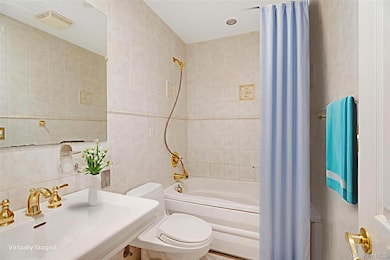 Bathroom featuring tile walls and shower / bath combination with curtain