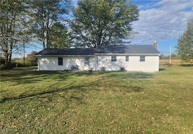 Back of property featuring a lawn and a chimney