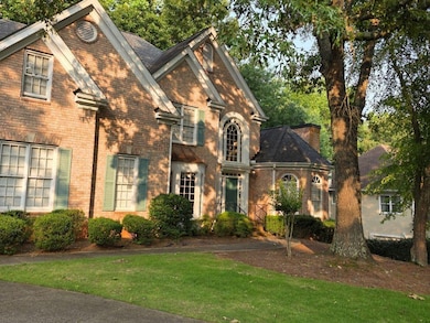View of front of home featuring brick siding and a front lawn