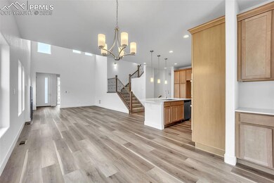 Kitchen with stainless steel dishwasher, light countertops, open floor plan, recessed lighting, and hanging light fixtures