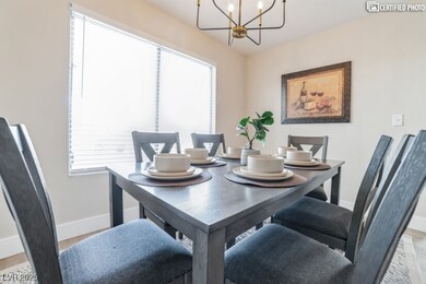 Dining area with baseboards, a chandelier, light w