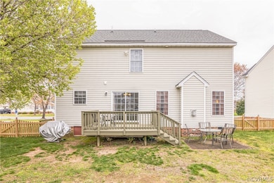 Rear view of house featuring a wooden deck, a yard