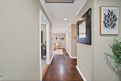 Corridor with dark wood-style floors, ornamental molding, and recessed lighting