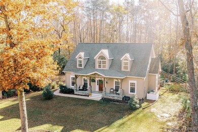 Cape cod home featuring a front lawn and covered p