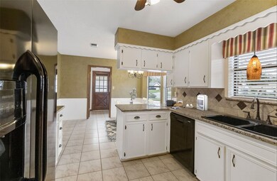 Spacious updated kitchen with granite tops, tiled back splash, tiled flooring, window over sink + plenty or cabinetry ~