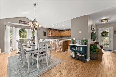 Dining area with lofted ceiling, light hardwood / 