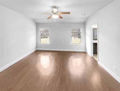 Empty room with ceiling fan, wood finished floors