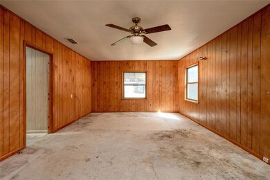 Unfurnished room featuring wood walls and ceiling 