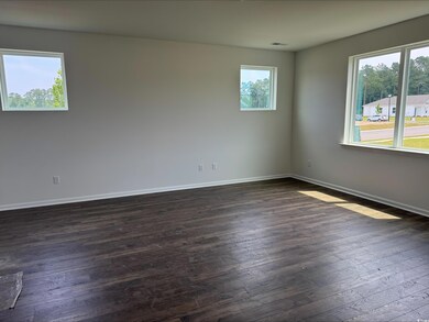 Empty room featuring dark wood-type flooring and baseboards