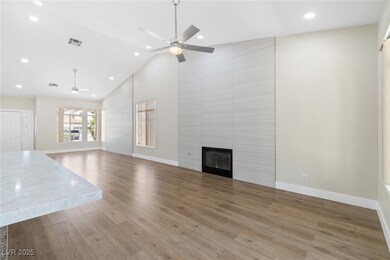 Unfurnished living room with ceiling fan, high vau