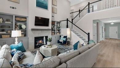 Living room featuring a high ceiling, wood finished floors, stairs, a fireplace, and baseboards