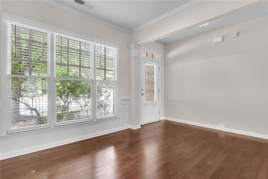 Empty room featuring crown molding and dark wood finished floors