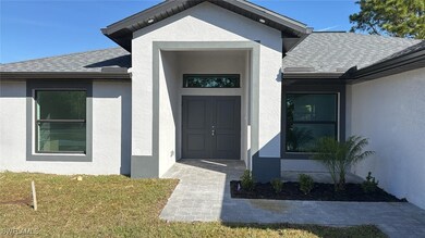 View of exterior entry featuring a lawn, roof with