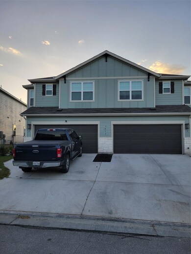 Traditional-style house with driveway, stone siding, a garage, and board and batten siding
