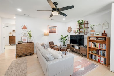 Living room featuring ceiling fan, visible vents,