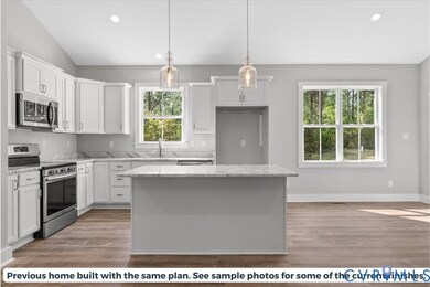 Kitchen featuring stainless steel appliances, decorative light fixtures, white cabinets, recessed lighting, and light wood-type flooring