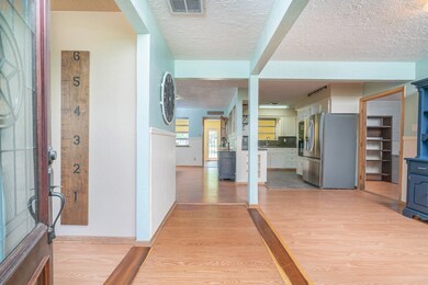 The view from the front door gives an explanatory overview of the first floor, with the foyer flanked by the formal dining on the right, family room on the left, with the kitchen and breakfast room straight ahead, and the sunroom just beyond.
