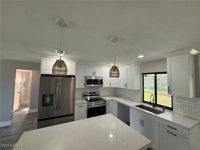 Kitchen with a textured ceiling, a sink, decorativ