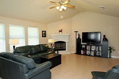 Spacious family room with cathederial style ceiling, a wall of windows with 2 inch faux blinds for natural lighting.