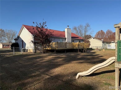 Back of house featuring a deck and a playground