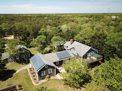 aerial showing bedroom wing to left, middle portion that is eat-in kitchen and the right part showing deck off master bedroom suite