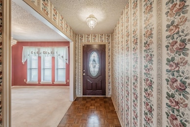Entrance foyer with wallpapered walls, baseboards,