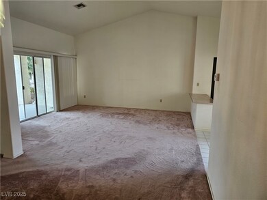Carpeted spare room featuring high vaulted ceiling