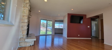 Unfurnished living room with wood finished floors and recessed lighting