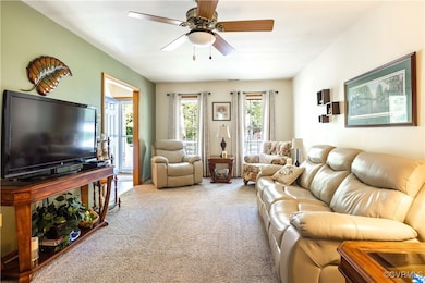 Living area with carpet floors and a ceiling fan