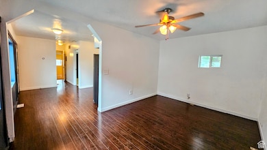 Unfurnished room featuring ceiling fan, dark wood-style floors, and a textured ceiling