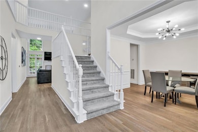 Beautifully maintained home with a dramatic two-story foyer, carpeted staircase, and elegant millwork.