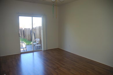 Spare room with a ceiling fan, dark wood finished