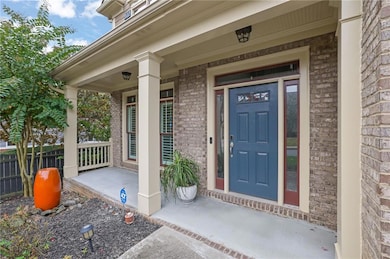 Property entrance featuring a porch and brick siding
