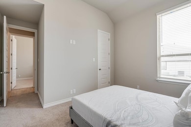 Bedroom featuring light colored carpet, baseboard