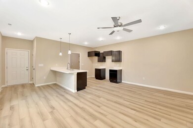 Kitchen with a peninsula, hanging light fixtures, a breakfast bar, light wood-type flooring, and ceiling fan