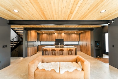 Kitchen with modern cabinets, recessed lighting, brown cabinets, a breakfast bar, and a center island with sink