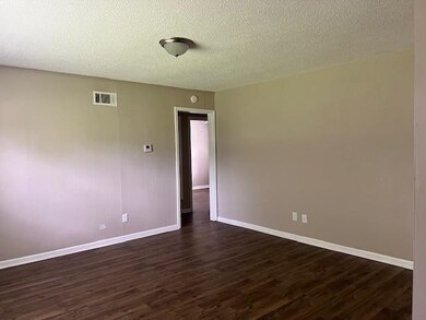 Empty room featuring a textured ceiling and dark h