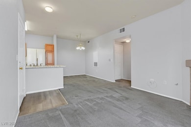 Unfurnished living room featuring a chandelier and