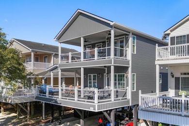 Back of house featuring a carport, a deck, and a ceiling fan