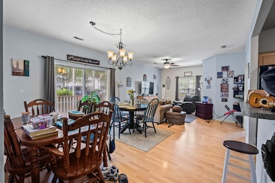 Dining space with ceiling fan with notable chandel