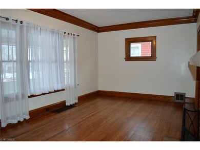 Spacious living room features beautiful natural woodwork and hardwood floor