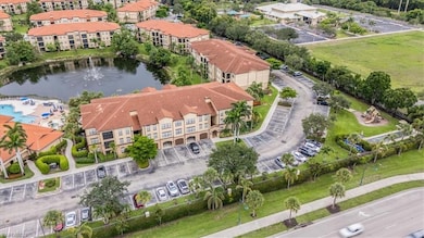 Aerial view of property and surrounding area featuring a nearby body of water and apartment complex