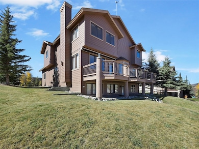 Rear view of property with a chimney, a yard, and