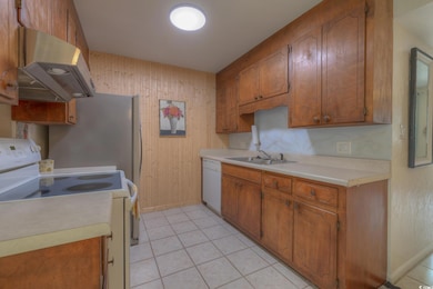 Kitchen with sink, light tile patterned floors, an