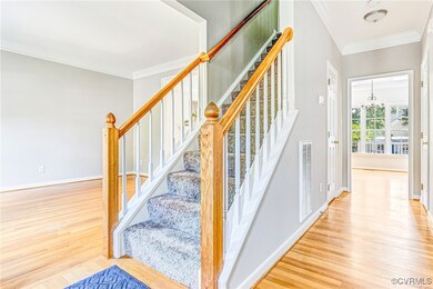 Staircase featuring ornamental molding, a chandelier, and hardwood / wood-style floors